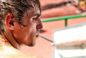 mlady muz s cigaretou v ustach
